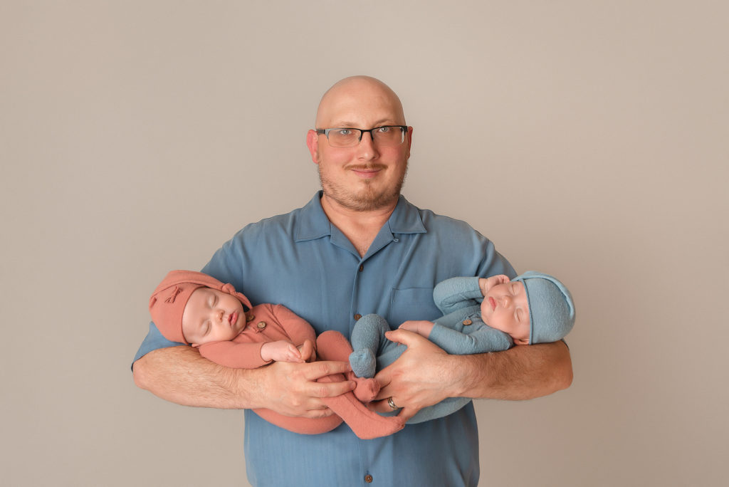 dad holds miracle twin babies during Las Vegas Studio newborn portraits
